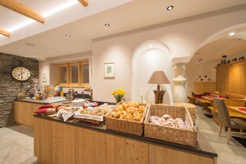 a kitchen with a counter filled with lots of food at Helmhotel in San Candido