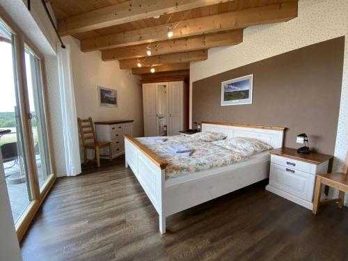 una camera con un grande letto e pavimenti in legno di Holiday home Red Milan a Irmenach