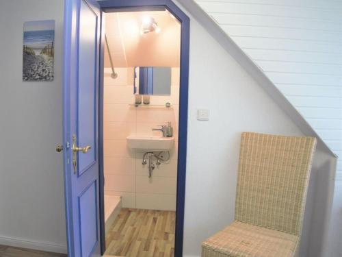 a bathroom with a sink and a toilet under a staircase at Holiday apartment Strandkrabbe in Ockholm
