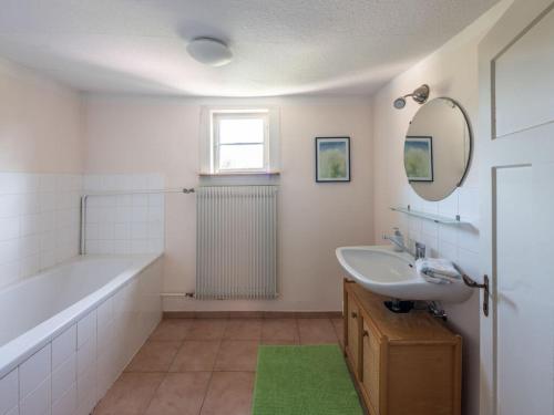 W łazience znajduje się wanna, umywalka i lustro. w obiekcie Holiday home gardener's house w mieście Unsleben