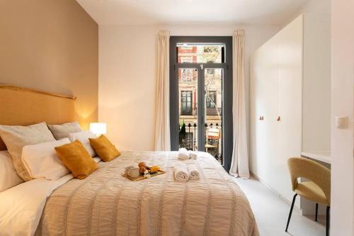 een slaapkamer met een bed met handdoeken erop bij Lodging Apartments Rambla Poblenou 12 in Barcelona