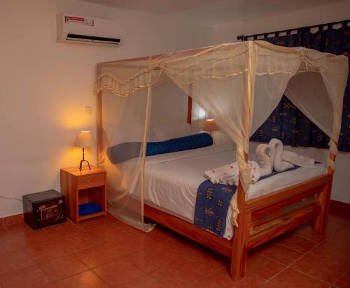 una camera con letto a baldacchino e comodino di AFEX Rivercamp a Giuba