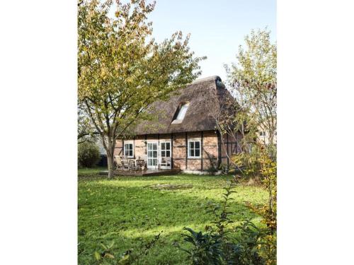 an old stone house with a thatched roof at Holiday home Kate keit in Altenhof