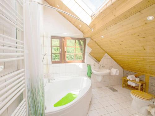 een badkamer met een wit bad en een houten plafond bij Holiday apartment Waldquartier Wackerberg in Kall