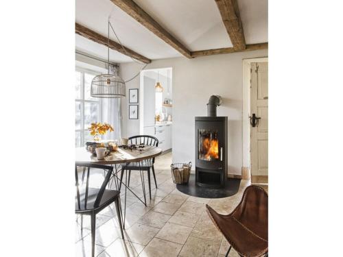 a living room with a table and a fireplace at Holiday home Kate keit in Altenhof