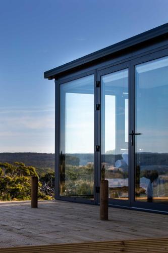 a glass house with a view of the countryside at Sky Ship 1 - Luxury Off-Grid Eco Accommodation in Cape Otway