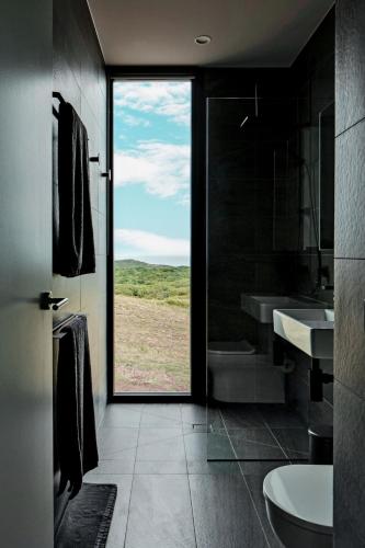 a bathroom with a view of a field through a door at Sky Pod 1 - Luxury Off-Grid Eco Accommodation in Cape Otway