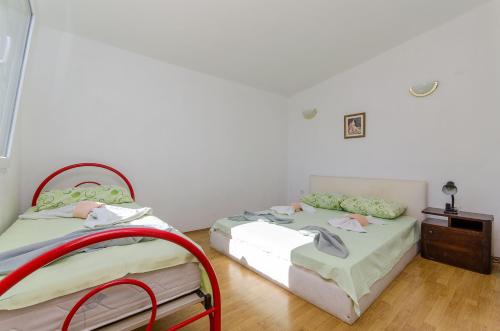 two beds sitting next to each other in a room at Apartments Laguna in Stomorska