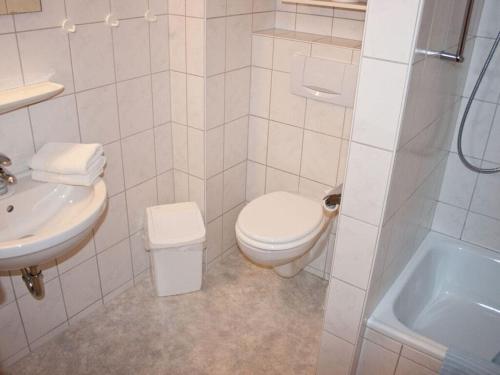 une salle de bain blanche avec toilettes et lavabo dans l'établissement Holiday apartment B in Haus Seewind, à Wittdün
