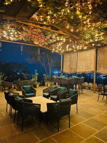 a patio with chairs and tables and lights at YAAN Udaipur in Udaipur