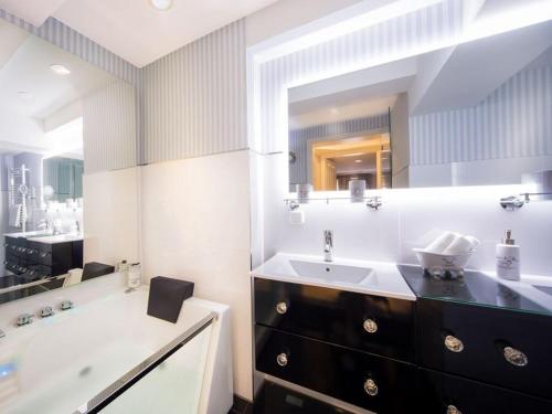 a bathroom with a sink and a tub and a mirror at Holiday apartment Family Lodge in Wernigerode