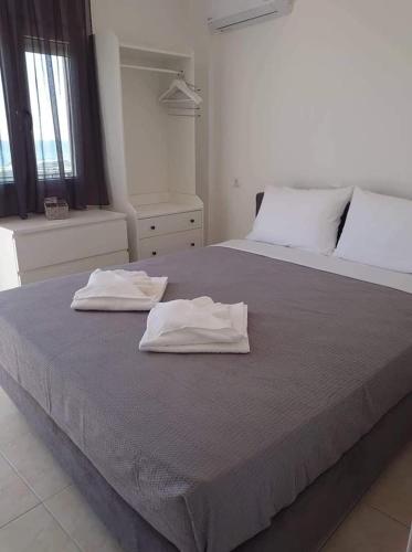 a bedroom with two white towels on a bed at Akrotiri rooms in Nea Mesangala