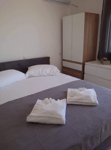 two white towels sitting on top of a bed at Akrotiri rooms in Nea Mesangala