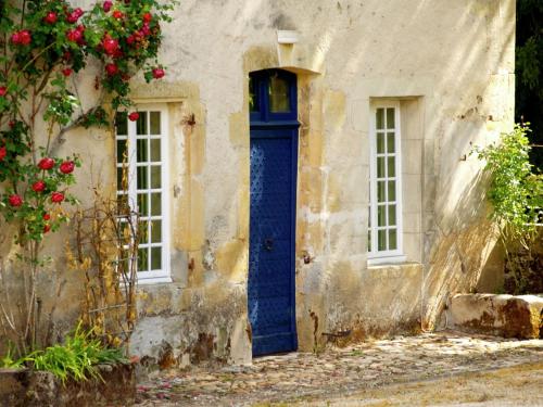 stary dom z niebieskimi drzwiami i oknami w obiekcie Romantic stay in a medieval castle with pool and restaurant among others w mieście Chaleix