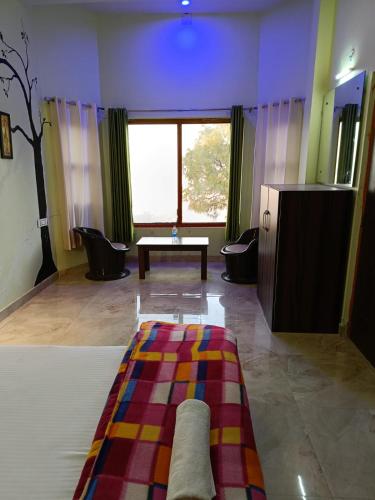 a room with a bed and a table and a window at Joshi Holiday Home Stay in Lansdowne