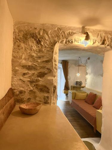 un salon avec un canapé et un mur en pierre dans l'établissement Felicità : appartement atypique centre Bastia, à Bastia