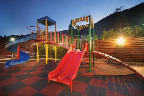 a playground with a slide and a slide at Vila Moldavia Class in Slănic-Moldova