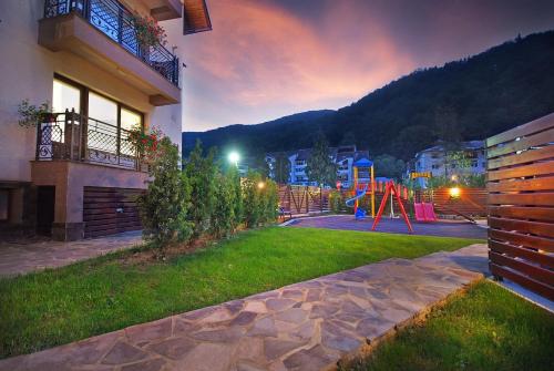 a yard with a playground in front of a building at Vila Moldavia Class in Slănic-Moldova