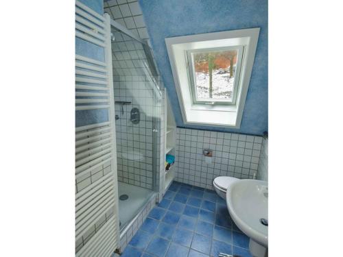 een badkamer met een wastafel, een bad en een toilet bij Holiday home Waldhaus am Burbach in Bad Berleburg
