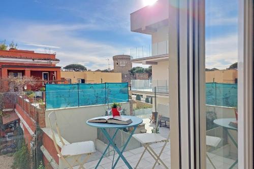 a balcony with a table and chairs and a view of a city at Vista Borgo - Lusso a Ostia Antica con Self Checkin e Free WIFI in Ostia Antica