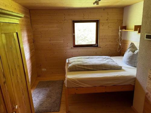 um pequeno quarto com uma cama num chalé de madeira em Inviting apartment in Schotten em Schotten