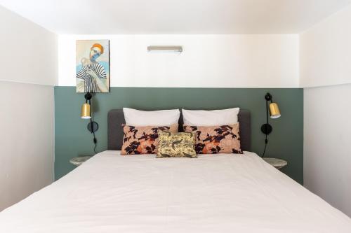 een slaapkamer met een groot wit bed en groene muren bij Amsterdam Dockside Flats in Amsterdam