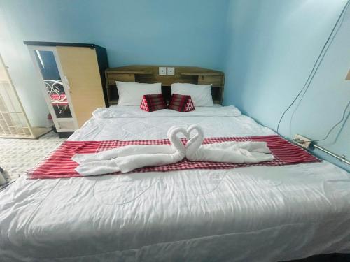 two swans towels are sitting on a bed at Noot's Guesthouse in Kanchanaburi