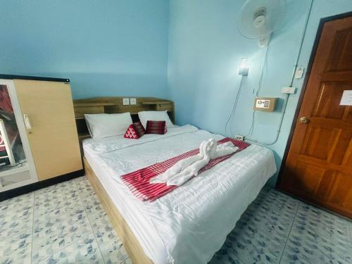 una camera da letto con un letto e un asciugamano sopra di Noot's Bar And Guesthouse a Kanchanaburi