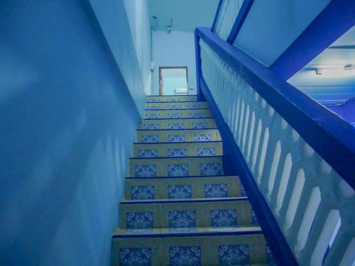 a set of stairs in a building with blue ceilings at Noot's Guesthouse in Kanchanaburi