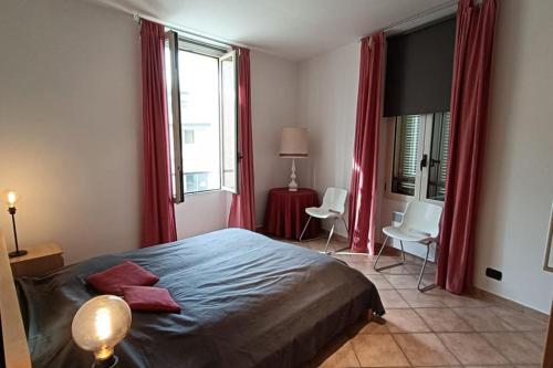 - une chambre avec un lit et 2 fenêtres avec des rideaux rouges dans l'établissement 3 pièces Clemenceau, à Cannes