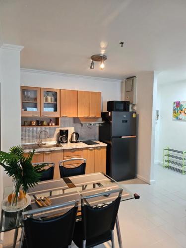 a kitchen with a table and a black refrigerator at Patong Tower Apartment in Patong Beach