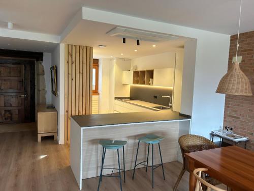 a kitchen with a bar with stools and a dining room at Casa Otxandi in Ochandiano