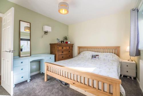 a bedroom with a bed and a dresser and a mirror at Rhianfa Manorbier in Manorbier