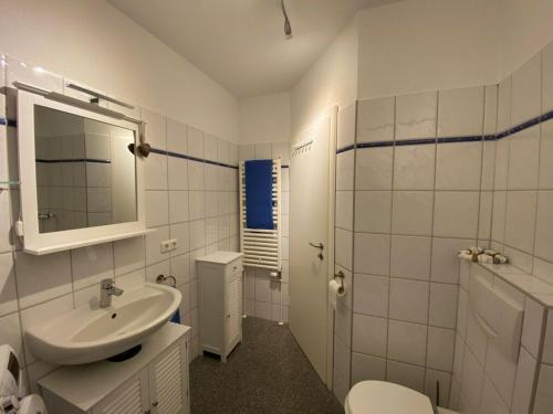 La salle de bains blanche est pourvue d'un lavabo et de toilettes. dans l'établissement Holiday apartment Fischbude, à Eckernförde