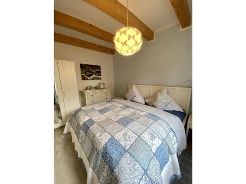 a bedroom with a bed with a blue and white comforter at Holiday home Elster-Swedenhaus 
