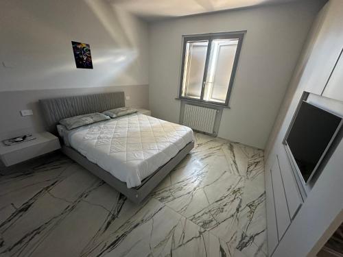 um quarto com uma cama e uma televisão num piso de mármore em Villa Alberto & Ilaria em Parma