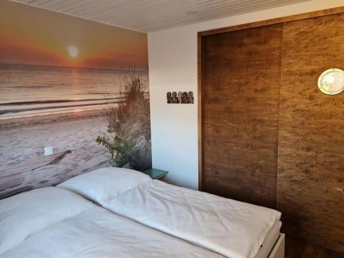 - une chambre avec un lit orné d'une peinture sur la plage dans l'établissement Apartment - East, à Großenbrode