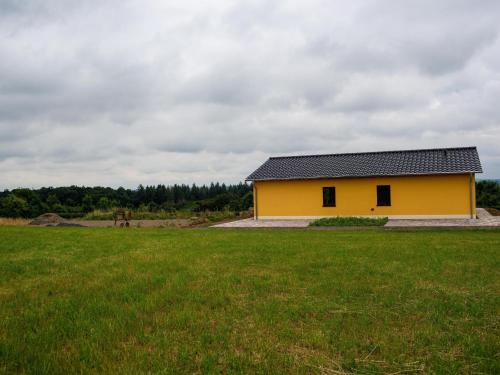 a yellow house in a field with a green field at Tranquil Holiday Home in Filz in the Eifel with Garden in Filz