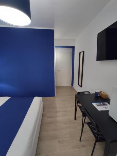 Zimmer mit einem Bett, einem Tisch und einer blauen Wand in der Unterkunft The 6th Floor in Rom