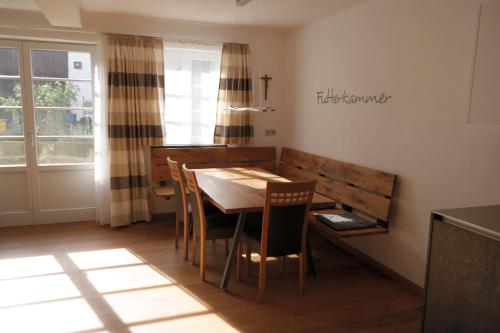 a dining room with a table and chairs and a cross on the wall at Ferienwohnung Christine in Strullendorf