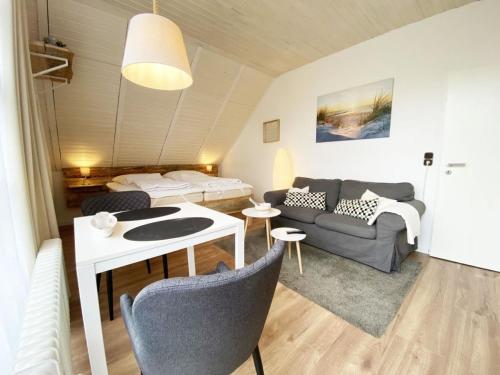 ein Wohnzimmer mit einem Sofa und einem Tisch in der Unterkunft Haus Wiesenweg - Apartment 1 in Wangerland