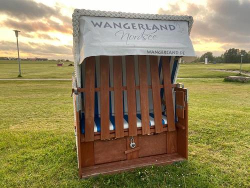 a wooden gate in the middle of a field at Ferien im Wangerland - Haus Wiesenweg - Apartment 1 1OG in Horumersiel