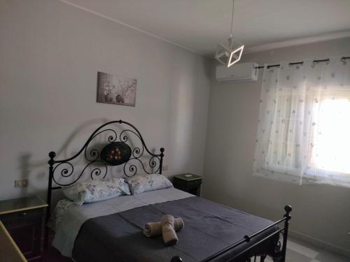 a bedroom with a bed with a teddy bear on it at Villetta Roby in Marina di Modica