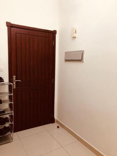 a room with a wooden door and a white wall at Room center in Muscat
