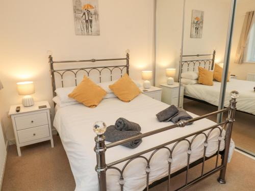ChathillにあるBeach Houseのベッドルーム1室(白いシーツとオレンジの枕が備わるベッド1台付)