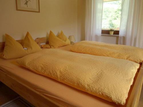 2 letti con coperte gialle e cuscini sopra di Holiday apartment Heller a Braunsbach