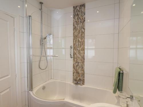 a bathroom with a tub and a shower with a curtain at Bousdale Cottage in Guisborough
