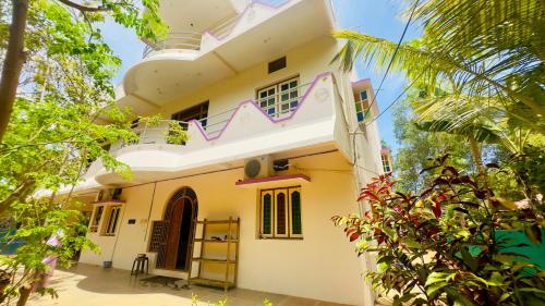 biały dom z balkonem i drzewami w obiekcie Lotus Garden - Near Matrimandir Center Auroville w mieście Auroville