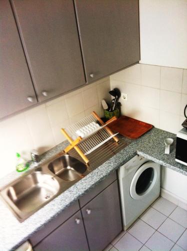 - un comptoir de cuisine avec évier et lave-linge dans l'établissement 1-bedroom apartment close to La Défense-Paris, à Puteaux
