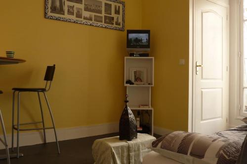 - une chambre avec des murs jaunes, un lit et une chaise dans l'établissement 1-bedroom apartment close to La Défense-Paris, à Puteaux